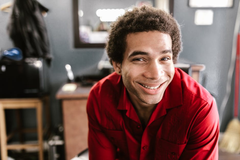 Portrait of a cheerful man in a red shirt with a blurred background indoors.