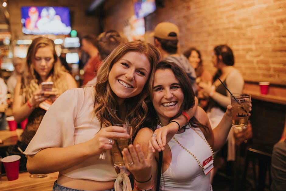 Women enjoying drinks and nightlife at a Denver bar, smiling and holding beverages.