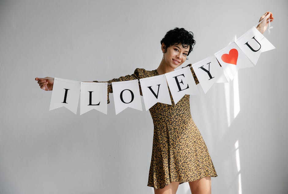 A cheerful woman holds a decorative 'I Love You' banner, perfect for Valentine's Day imagery.