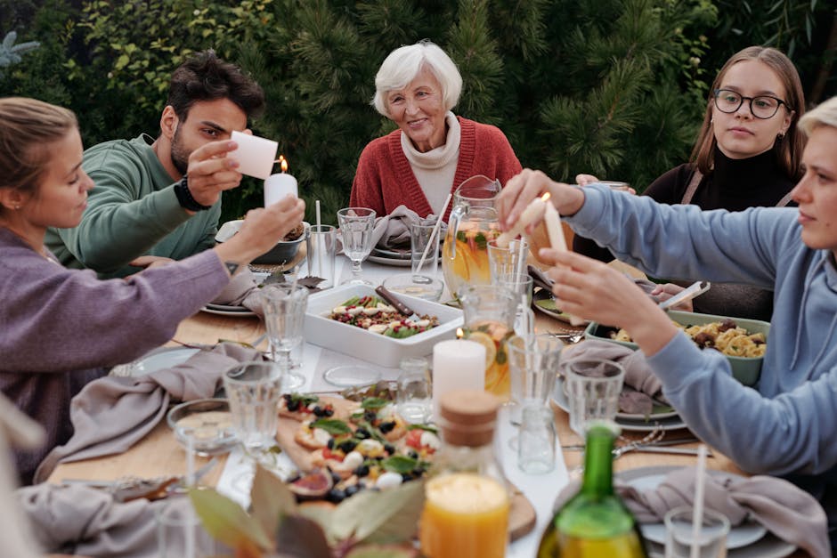 A family enjoys an outdoor autumn gathering with food, drinks, and candles.