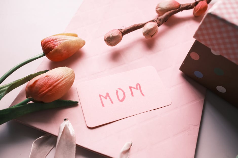 Close-up of a Mother's Day card and tulips on a pink background, evoking warmth and appreciation.