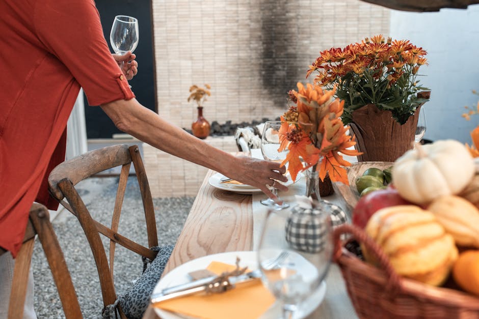 An inviting fall-themed table setting with autumn flowers and decorations for Thanksgiving.