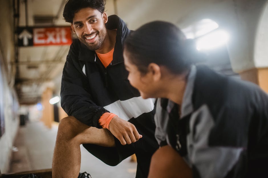 Two friends enjoying a cheerful conversation indoors, creating a warm and friendly atmosphere.