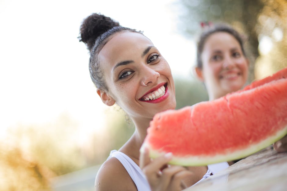Two young women enjoying a refreshing summer day with watermelon, radiating happiness and health.