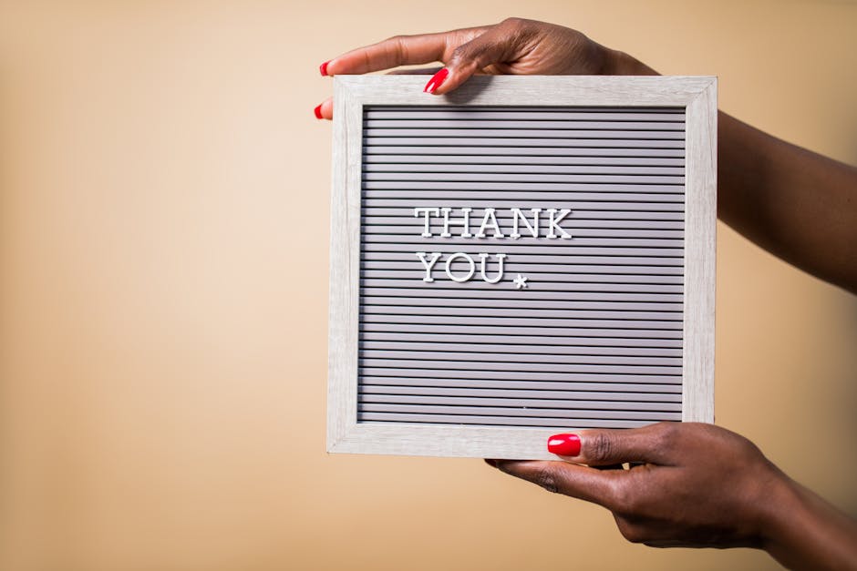 Close-up of hands holding a thank you sign, perfect for expressing gratitude.