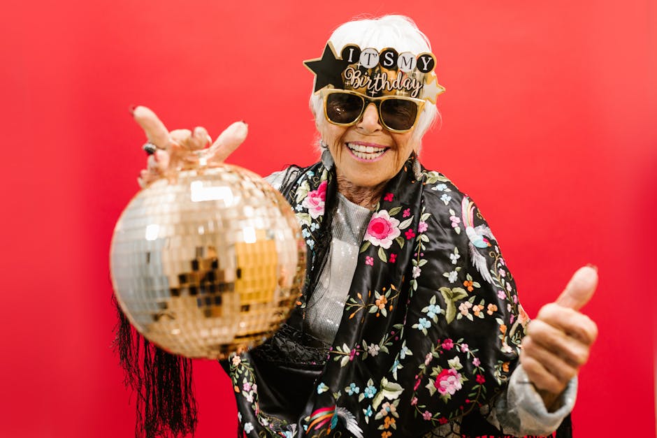 Joyful senior woman celebrating her birthday with a disco ball in a festive atmosphere.