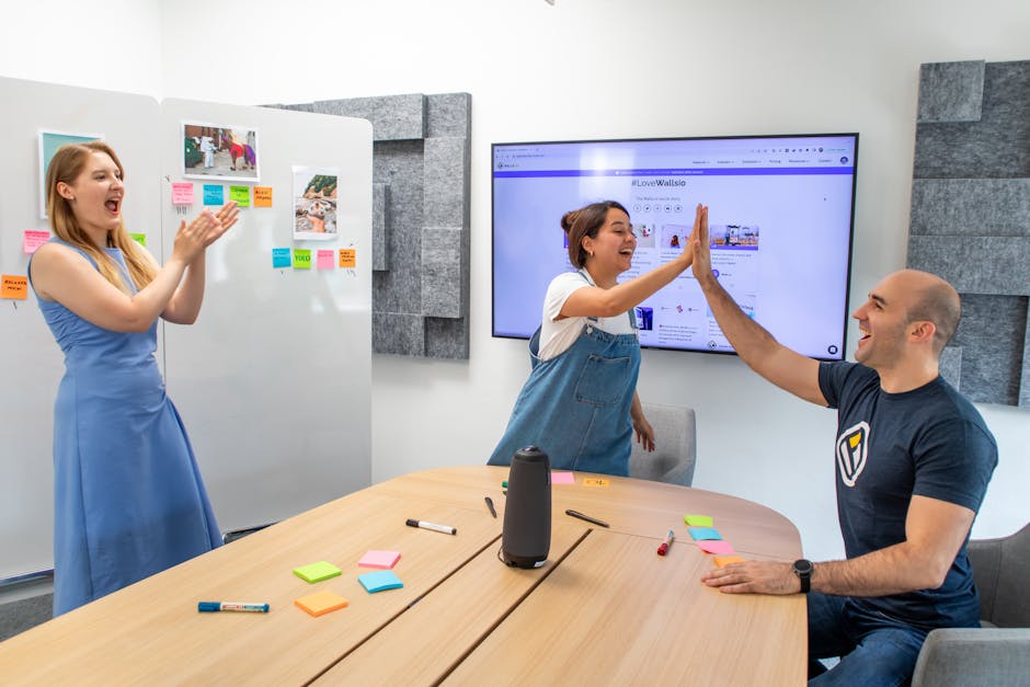 Colleagues share a high five in a modern office, celebrating teamwork and success.